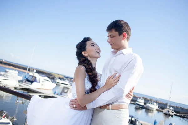 Sposa e sposo sullo sfondo di yacht club, giovane coppia felice guardando l'un l'altro — Foto Stock