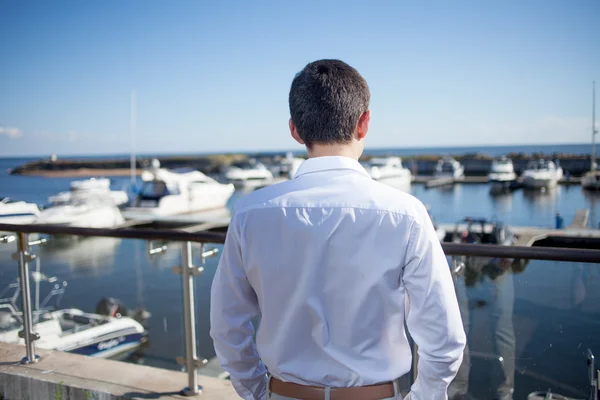 young man near the yacht club,  view from  back