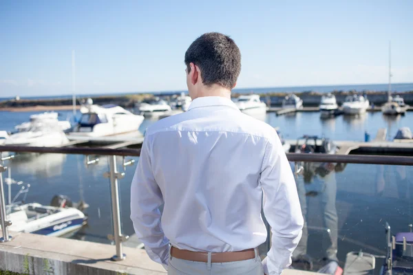 Jonge man in de buurt van de yacht club, uitzicht vanaf de achterkant — Stockfoto