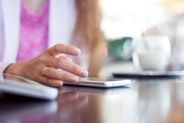 Chica sostiene un teléfono inteligente, pequeña profundidad de campo, enfoque suave — Foto de Stock