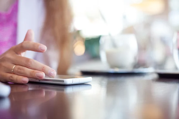 Flickan har en smartphone, litet skärpedjup, mjukt fokus — Stockfoto