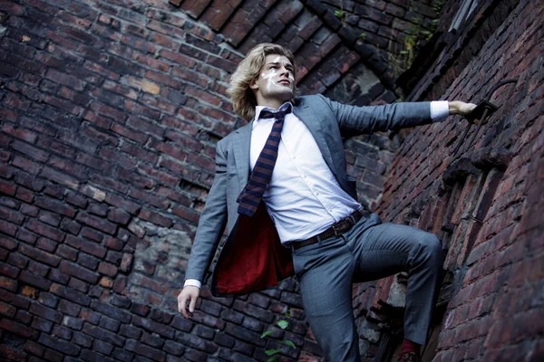 Businessman warrior. Young man  with  war paint on his face climbs up the wall , concept — Stock Photo, Image