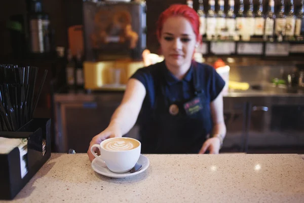 Happy girl Barista gives coffee  to the customers — Stock Photo, Image