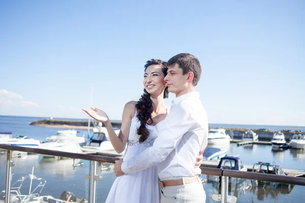 Mariée et marié sur le fond de yacht club, jeune couple heureux regarder à gauche — Photo