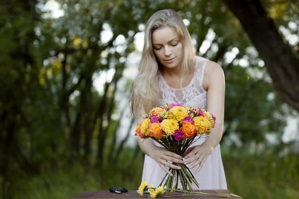 아름 다운 젊은 여성 꽃집입니다. 공원에서 소녀는 꽃다발을 그립니다. 야외 — 스톡 사진