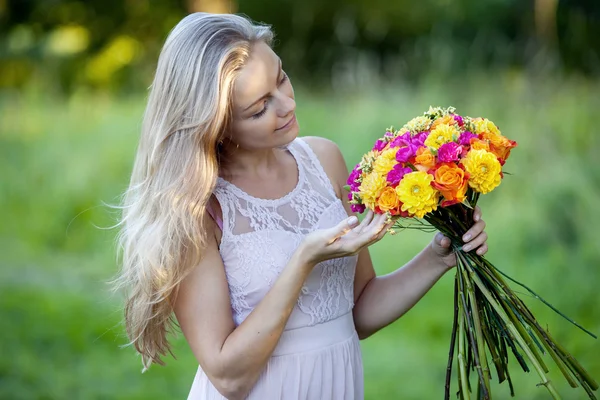 Jonge mooie vrouw bloemist. Het meisje in het Park trekt een boeket. Buiten — Stockfoto