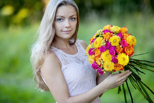 Giovane bella donna fiorista. La ragazza del parco disegna un bouquet. All'aperto — Foto Stock