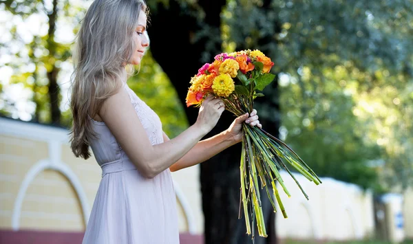 Junge schöne Floristin. das Mädchen im Park zeichnet einen Strauß. Außenbereich — Stockfoto