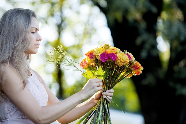 Joven florista hermosa mujer. La chica del parque dibuja un ramo. Exterior —  Fotos de Stock