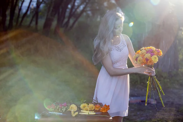 Young beautiful woman florist. The girl in the Park draws a bouquet. Outdoor — Stock Photo, Image