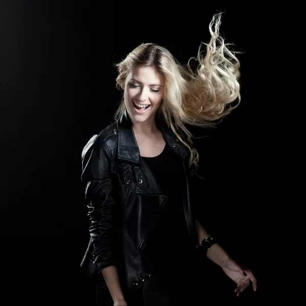 Улыбающаяся молодая женщина танцует на черном фоне — стоковое фото