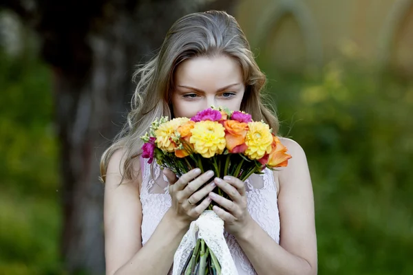 Jonge mooie vrouw met een heldere boeket, meisje ruikende bloemen — Stockfoto