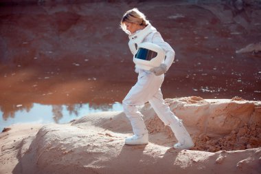 Water on Mars, futuristic astronaut without a helmet in another planet, image with the effect of toning clipart