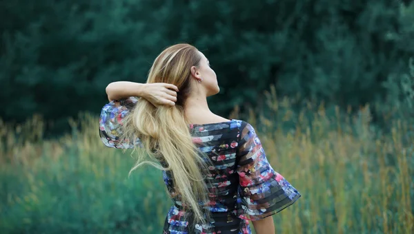 Krásy dívka venku těší přírody, blonďatá dívka v šatech na louce — Stock fotografie