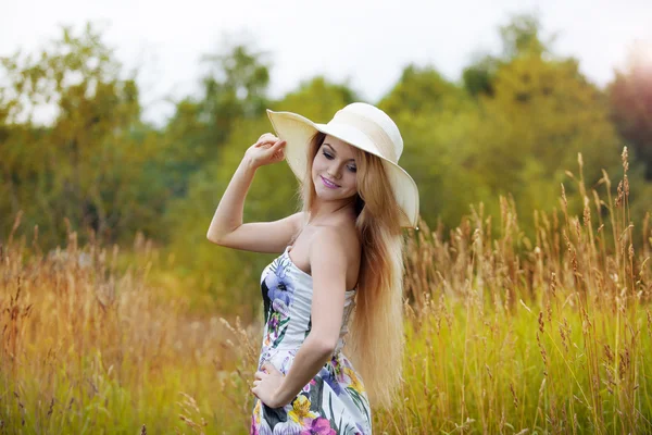 Uroda kobiety w słomkowym kapeluszu sam na sam z natury, koncepcja wolności. — Zdjęcie stockowe