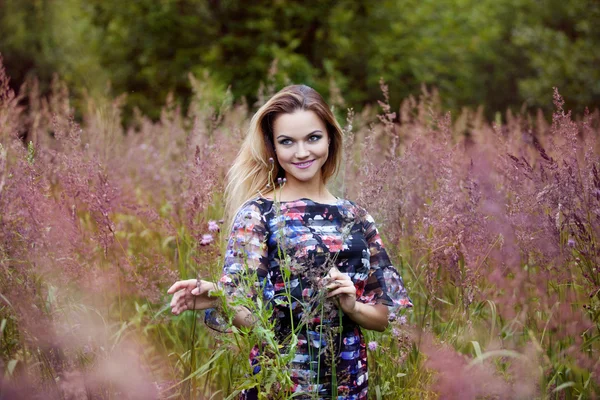 Skönhet flicka utomhus njuta av naturen, blond tjej i klänning på en äng — Stockfoto