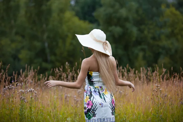 Krása ženy venku užívat přírodu. Dívka ve slamáku, zpět — Stock fotografie