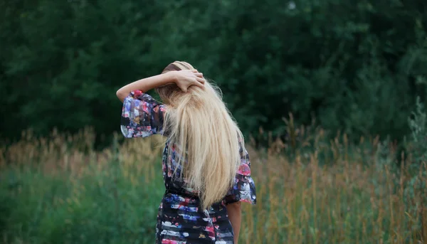 Piękna dziewczyna na zewnątrz korzystających natura, blond dziewczyna w sukience na łące — Zdjęcie stockowe