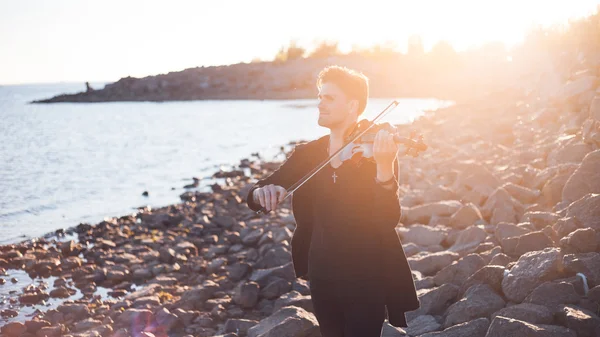 Violinist playing a violin,  young man plays on the background of  sea — Stock Photo, Image