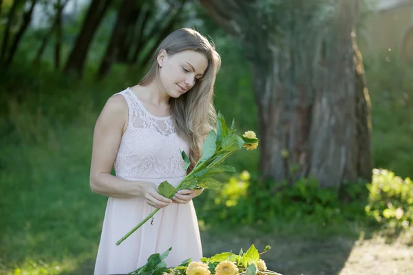 Unga vackra kvinnan florist. Flickan i parken ritar en bukett. Utomhus — Stockfoto