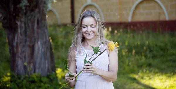 Mladá krásná žena květinářství. Dívka v parku nakreslí kytice. Venkovní — Stock fotografie