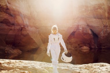 futuristic astronaut without a helmet in rays of another sun, image with the effect  toning clipart