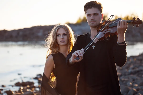 Violoniste et fille, jeune homme joue sur fond de mer — Photo