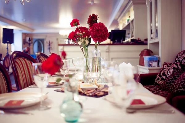 Interior do restaurante, grande mesa colocada para banquete, decorado em tons de Borgonha — Fotografia de Stock