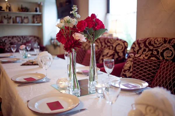 Wnętrze restauracji, duży stół nakryty na bankiet, ozdobiony kolorami burgundzkimi — Zdjęcie stockowe