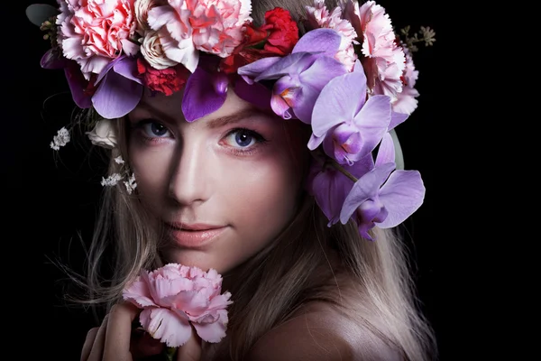 Stående ung vacker kvinna i krans av blommor, svart bakgrund — Stockfoto