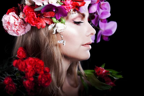 Jonge mooie vrouw in krans van bloemen, zwarte achtergrond. Profiel — Stockfoto