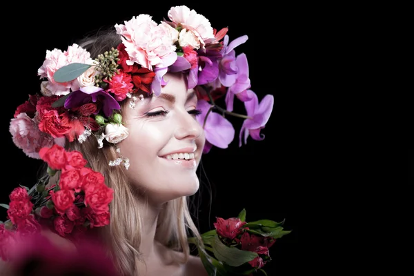 Uśmiechnięta młoda piękna kobieta w wieniec z kwiatów, czarne tło. Miejsce dla tekstu po prawej stronie — Zdjęcie stockowe