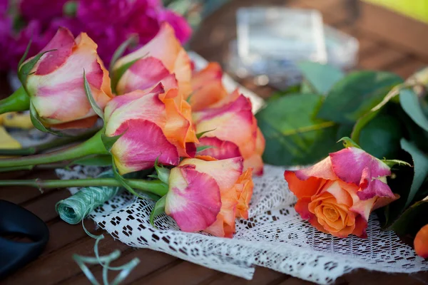 Fiori e strumenti sul tavolo, fiorista sul posto di lavoro, still life vista dall'alto — Foto Stock