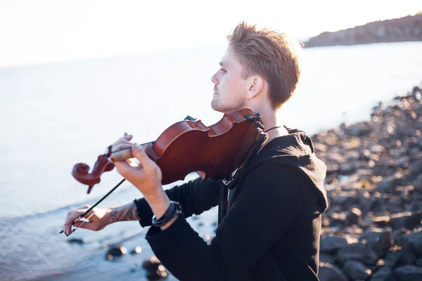 Violoniste jouant du violon, jeune homme joue sur fond de mer — Photo