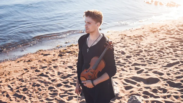 Violinist playing a violin,  young man plays on the background of  sea — Stock Photo, Image