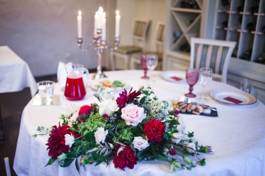 Restoranın içinde, Burgundy tonlarında dekore edilmiş büyük bir masa hazırlandı.