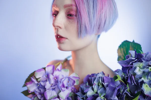 Menina incomum com flores azuis, foco na flor — Fotografia de Stock