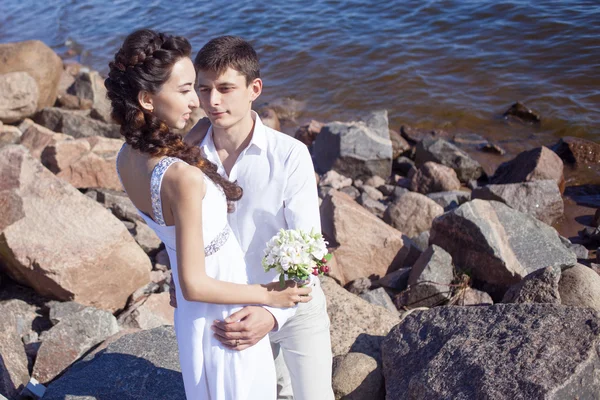 Net getrouwd gelukkige paar op een rotsachtige strand — Stockfoto