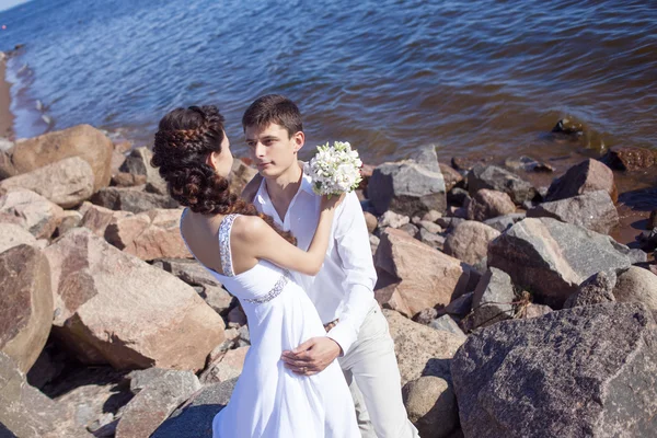 Net getrouwd gelukkige paar op een rotsachtige strand — Stockfoto