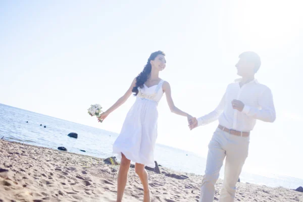 Just married happy couple running on a sandy beach — Stock Photo, Image