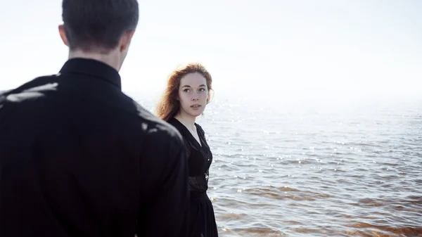 Красивая молодая пара, обнимающая стоя в море, эффект раскрашивания фотографий — стоковое фото