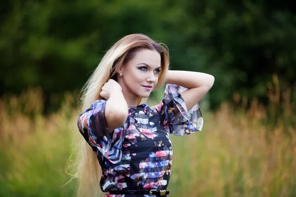 Menina beleza ao ar livre desfrutando da natureza, menina loira no vestido em um prado — Fotografia de Stock