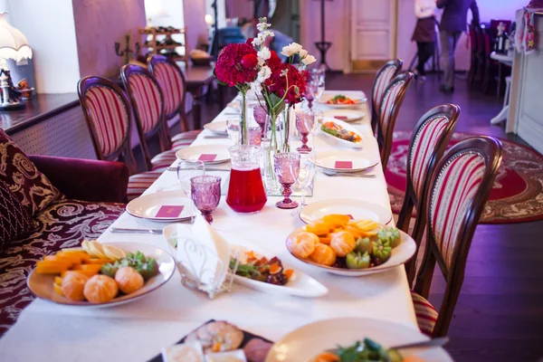 Interieur des Restaurants, großer Tisch für Bankett gedeckt, in Burgundertönen gehalten — Stockfoto