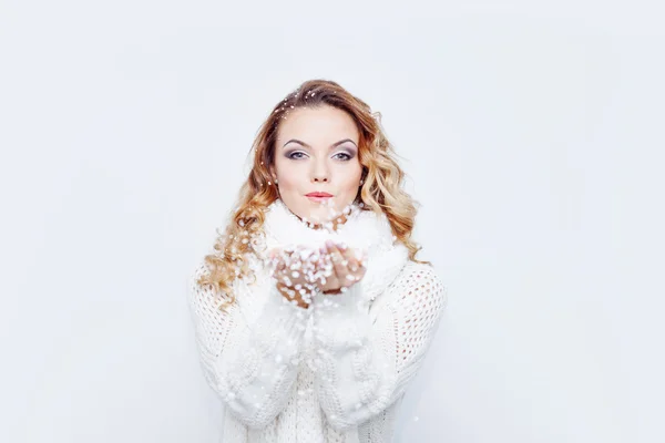 Mujer que sopla nieve, chica en bufanda de punto cálido y guantes, retrato sobre fondo blanco, lugar para su texto —  Fotos de Stock