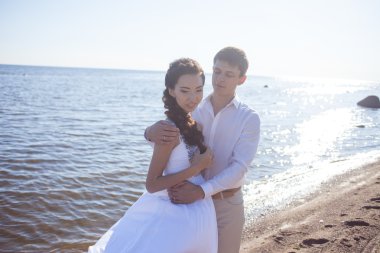 Sadece evli mutlu gelin ve damat, genç çift sahilde kucaklayan