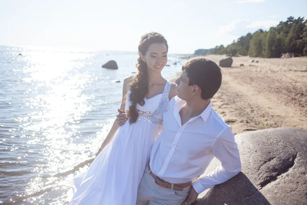 Appena sposati sposa felice e sposo, giovane coppia abbraccia sulla spiaggia — Foto Stock