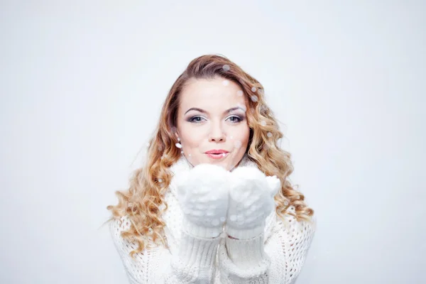 Mujer que sopla nieve, chica en bufanda de punto cálido y guantes, retrato sobre fondo blanco, lugar para su texto — Foto de Stock