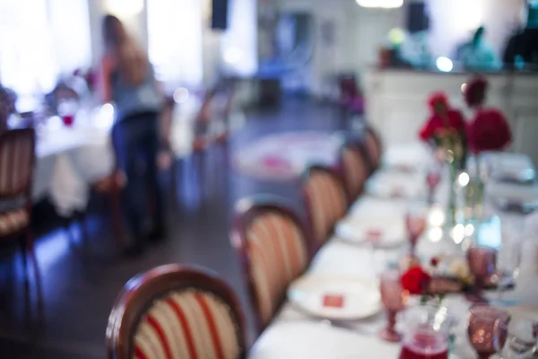 Wnętrze restauracji, duży stół na bankiet, urządzone w odcieniach bordo, rozmazane tło — Zdjęcie stockowe