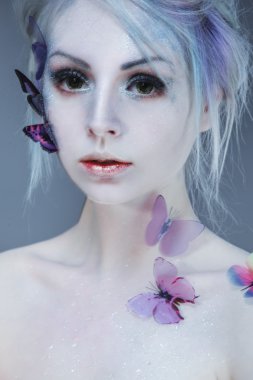 Kelebek güzel kızla. Güzellik yüz. Yaratıcı makyaj ve saç stili. öğe, dikey, bulanıklık