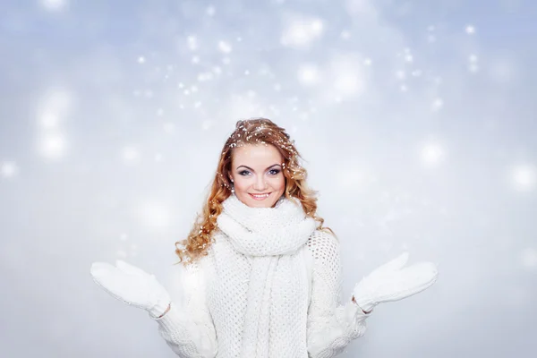 Vrouw in warme gebreide handschoenen en sjaal gelukkig sneeuwval, vangen sneeuwvlokken op handen. — Stockfoto